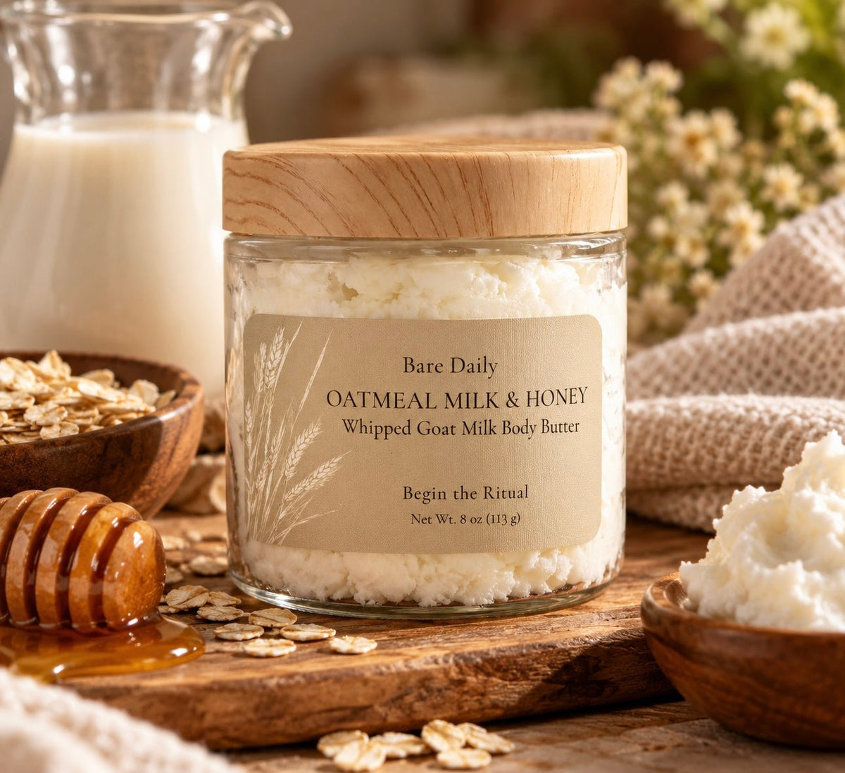 Bare Daily Oatmeal Milk & Honey Whipped Goat Milk Body Butter 8 oz jar with a wood grain lid on a rustic table with a honey dipper, rolled oats, and a milk pitcher.
