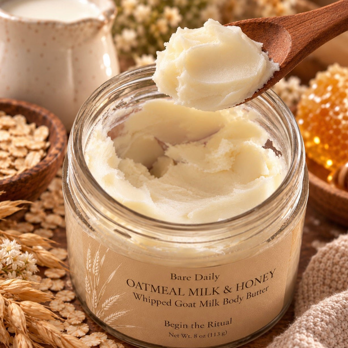 Close-up texture of Bare Daily Oatmeal Milk & Honey Whipped Goat Milk Body Butter being scooped out of an 8 oz glass jar with a wooden spoon.