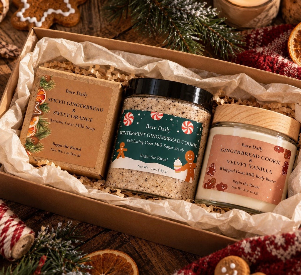 A Bare Daily gift set in a kraft box filled with shredded paper, featuring a spiced gingerbread and sweet orange artisan goat milk soap bar, a whipped coat milk body butter jar, and a wintermint gingerbread cookie cleansing milk scrub jar.