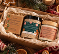 A Bare Daily gift set in a kraft box filled with shredded paper, featuring a spiced gingerbread and sweet orange artisan goat milk soap bar, a whipped coat milk body butter jar, and a wintermint gingerbread cookie cleansing milk scrub jar.