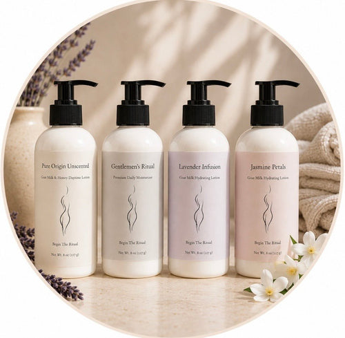 Four bottles of different scented lotions on a neutral background with flowers and lavender.